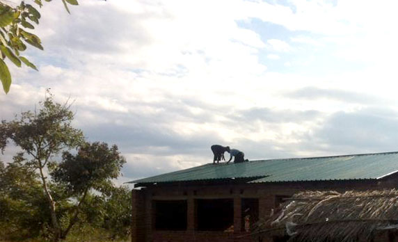 Construction workers install the roof