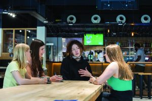 Students sitting round a table having a coffee and chat.