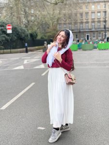 Syeda posing for a photo on a London street.