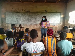 A woman standing in a classroom teaching wearing face mask